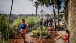 Die Menschen sprühen gerne Wasser, während eine Hitzewelle über Paris, Frankreich, rollt