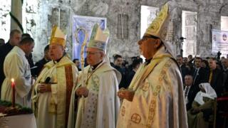Iraqi priests lead the prayers during a Christmas mass at the Saint Paul"s church in Mosul city, northern Iraq, 24 December 2017