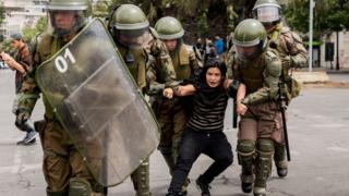 carabineros se llevan a una manifestante