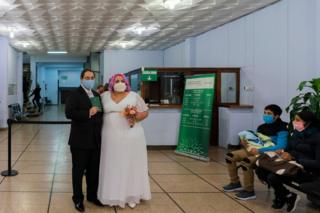 Newlyweds pose for a photo after they were married at the civil registry office