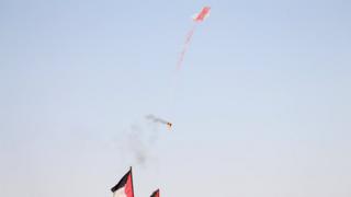 طائرة ورقية تحمل شعلة من النار