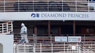 Рабочий в защитном снаряжении замечен на круизном лайнере Diamond Princess на круизном терминале пирса Дайкоку в Иокогаме, к югу от Токио