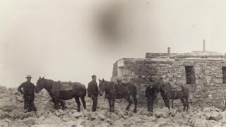 Eich a' toirt chlachan gu mullach na beine gus an stèisean a thogail.