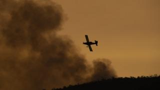 Firefighting aircraft dumps retardant on a blaze in the Orroral Valley on 30 January