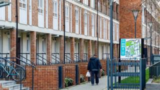 man walking through housing estate