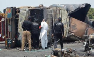 La policía revisa el camión de combustible que explotó y se quemó el 25 de junio en Punyab, Pakistán.