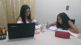 Irmãs Emily e Camila estudando em casa