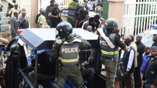 Nigerian ant-riot police officers escort a suspected kidnap kingpin to prison after he was arraigned at the Lagos State High Court