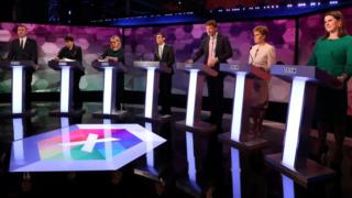 Party representatives standing at podiums during the BBC debate