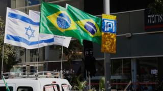 Israeli and Brazilian flags hanging on the outside of the building housing the offices of the Brazilian Embassy in Tel Aviv