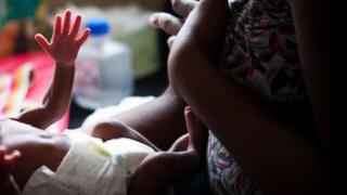 Une mère et son bébé portant une couche - archives