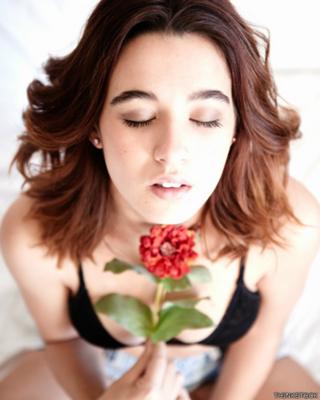 Imagen genérica de una mujer con cara de placer y una flor