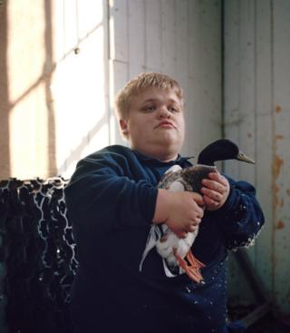 A boy holding a duck
