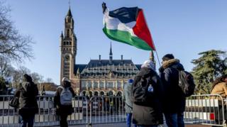 Palestinian supporters raise flag outside the ICJ (26/01/24)