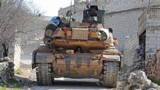 A Turkish tank drives through the village of Matarim in the Syrian province of Idlib (17 February 2020)