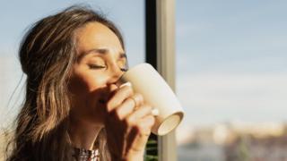 A woman drinking a mug of tea