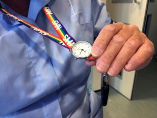 A nurse holds her watch