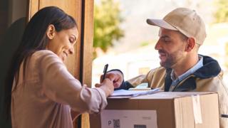 A woman signs for a parcel