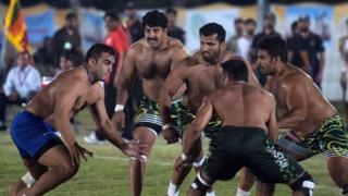 This file photograph taken on May 6, 2016, shows an Indian kabaddi player (L) as he attempts to tag a Pakistani opponent during their final match of the 3rd Asian Kabaddi Circle Style Championship 2016 in Wah some 45 kilometers from Islamabad.