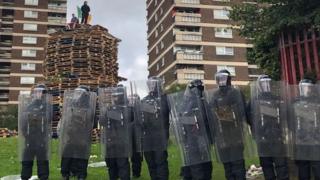 Police surrounding the bonfire in north Belfast