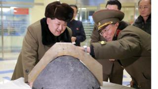 North Korean leader Kim Jong-un looks at a rocket warhead tip after a simulated test of atmospheric re-entry of a ballistic missile