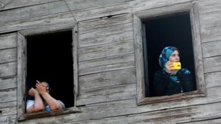 An Egyptian woman looks from the window as her daughter takes pictures during the funeral of Syed Tafshan, who died in clashes with residents of the Nile island of al-Warraq island, when security forces attempted to demolish illegal buildings, in the south of Cairo, Egypt July 16, 2017.