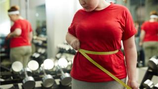 Woman in gym with measuring tape