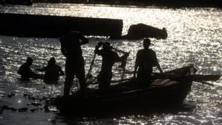 Un grupo de pescadores arrastran un barco en el Caribe