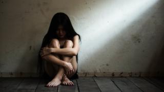 Mujer sentada en el suelo.