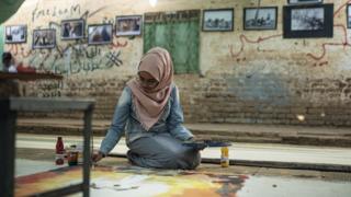 An artist working on a canvas roll at the vocational traing centre in Khartoum, Sudan