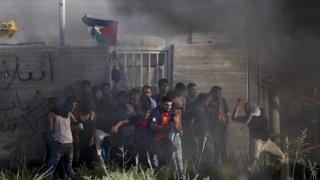 Palestinians throw stones at Israeli troops across the Gaza border fence. 9 October 2015