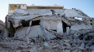 Civil defence members inspect a site attacked by what activists said were Russian aircraft in Sheikh Miskeen, Syria (24 December 2015)