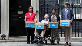 Campaigners from Age UK prepare to hand in a petition to maintain free TV licences for over-75s to 10 Downing Street