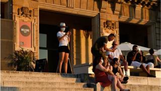 People on the steps of National Art Museum of Barcelona after Catalan government ordered the closure of nightclubs and event halls following a surge in coronavirus cases