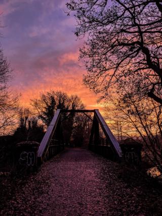 A multi-coloured sunset over a bridge