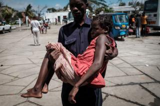 Девочку, которая была эвакуирована на лодке из изолированного района Бузи, несут сотрудники Красного Креста по прибытии в центр эвакуации средней школы Самора М. Машел в Бейре, Мозамбик, 21 марта 2019 года.