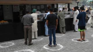 Customers wait to buy food in Lahore, Pakistan