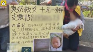 Женщина на коленях на улице в Китае, кормит грудью ребенка. На табличке рядом с ней изображена ее больная девочка и написано китайскими иероглифами. На переднем плане есть два полиэтиленовых пакета, очевидно наполненных грудным молоком.