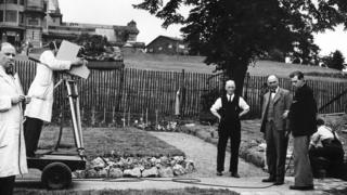 Picture shows gardening in the grounds of Alexandra palace featuring C.H. Middleton (centre) discussing the relative merits of various paving stines with the contractor Mr Moss (left).