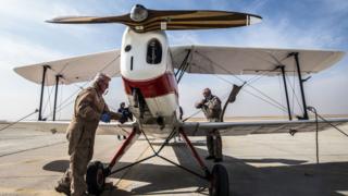 A German pilot checks his Bu 131 Bucker Jungmann biplane after landing at an airfield in Cairo, Egypt during the Vintage Air Rally (VAR) on November 13, 2016.