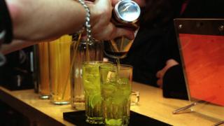 Бармен разливает напитки в баре Fluid по адресу 40 Charterhouse Street в Клеркенуэлле, Лондон.