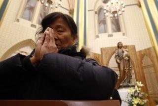 A woman prays at the Xishiku Catholic Church in Beijing, China