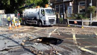 Road with pothole and other debris on it