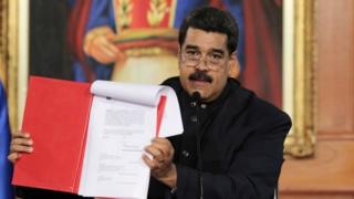 Президент Венесуэлы Николас Мадуро держит документ во время выступления во время церемонии во Дворце Мирафлорес в Каракасе, Венесуэла, 1 мая 2017 года.