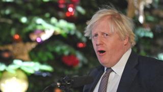 Boris Johnson next to a Christmas tree