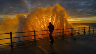 Man with waves at sunrise