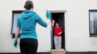 A volunteer delivers a food box to a lady in County Antrim