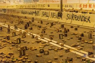 HONG KONG, CHINA - NOVEMBER 18: Protesters use bricks to barricade near Hong Kong Polytechnic University in the Tsim Sha Tsui district on 18 November 2019 in Hong Kong