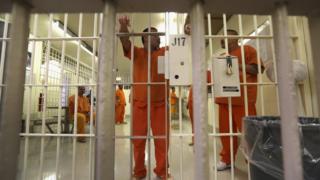 Immigration detainees stand behind bars at the Immigration and Customs Enforcement (ICE), detention facility on February 28, 2013 in Florence, Arizona.