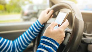 Woman using mobile phone while driving